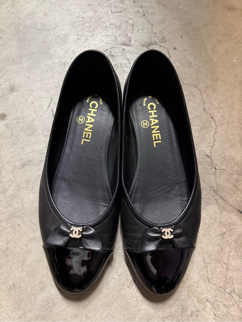 CHANEL Black Leather Ballet Flats with Patent Cap Toe and CC Charm